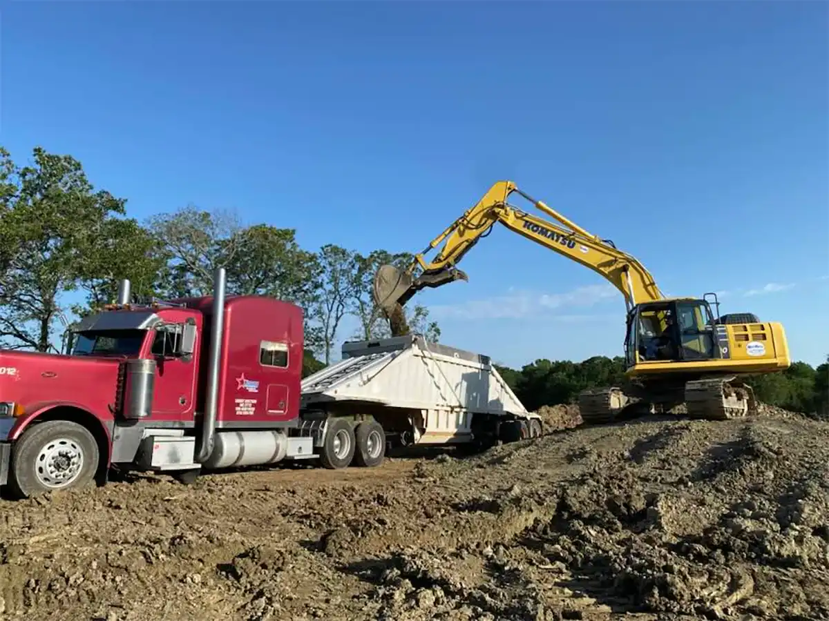 excavator loading dirt into a truck