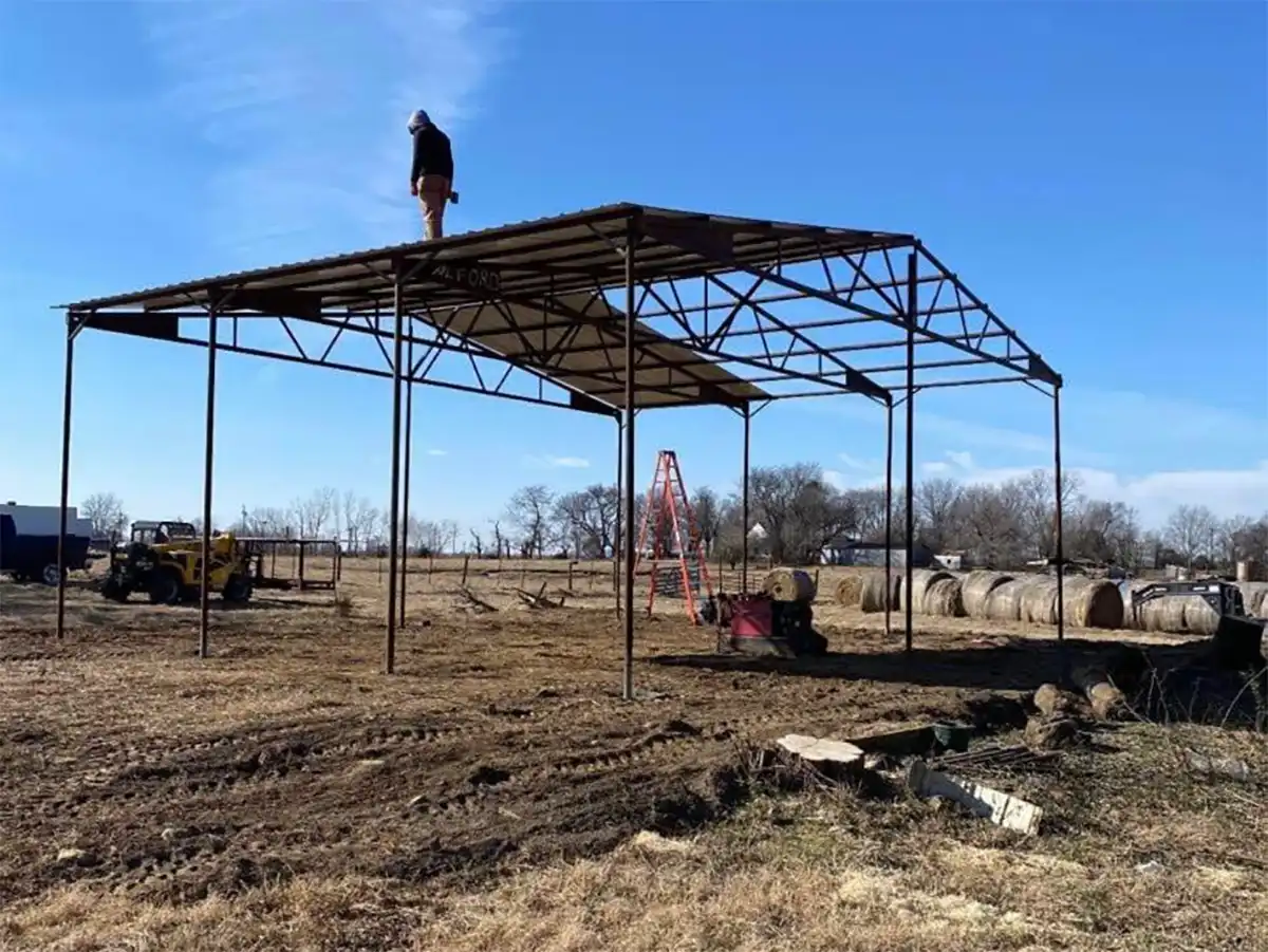 man constructing a metal building