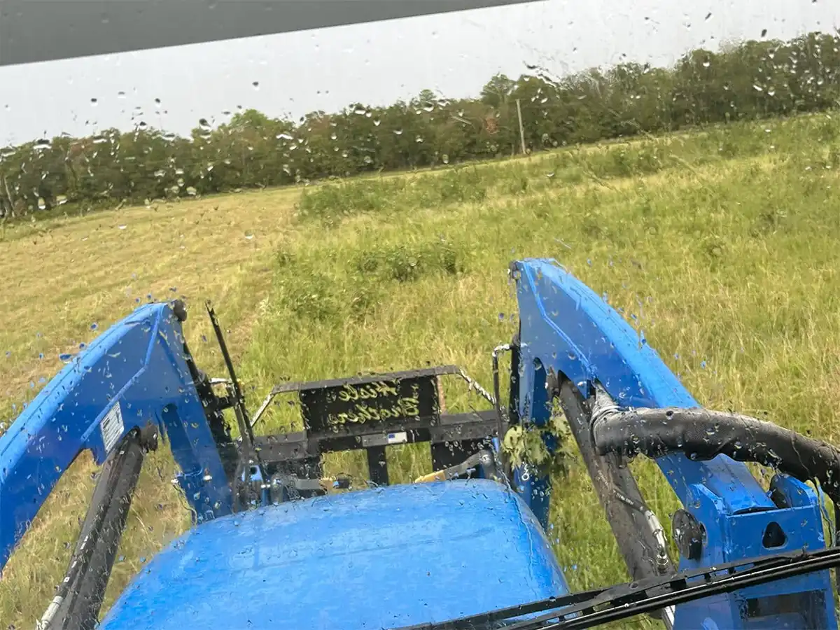 tractor cutting a field of tall grass